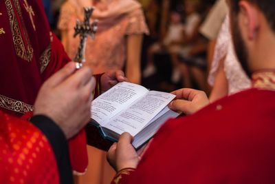 Midsection of priest reading bible at church