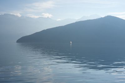 Scenic view of sea and mountains against sky