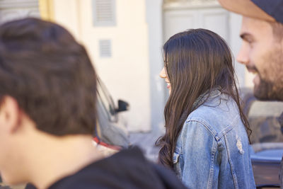 Side view of friends walking against wall