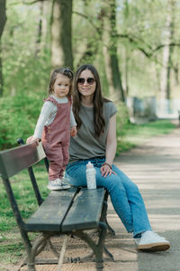 Young woman sitting on bench in park