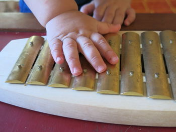 Cropped hands of baby touching xylophone toy