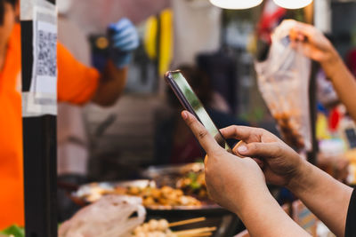 Woman use smartphone scan qr code in food store.