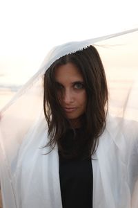 Portrait of young woman standing against sky