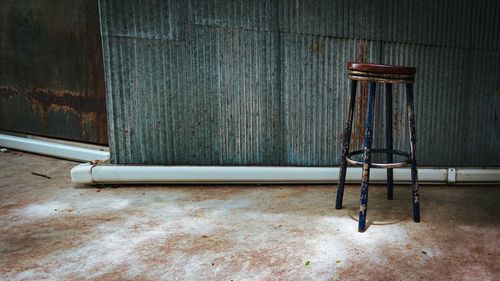 Empty chairs against wall in old building