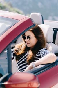 Woman wearing sunglasses sitting in car