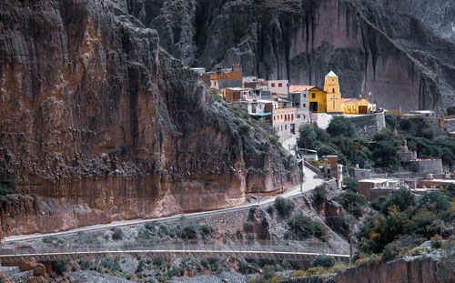 View of buildings on rock with mountain in background