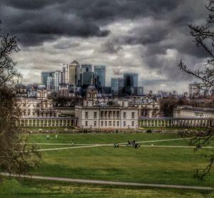 View of houses in city against cloudy sky