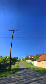 Electricity pylons against blue sky