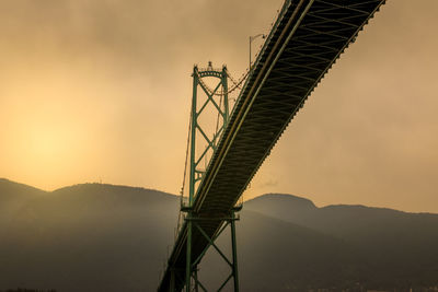 Low angle view of suspension bridge against sky