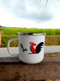 Close-up of coffee cup against sky