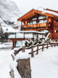 Snow covered houses by building against sky