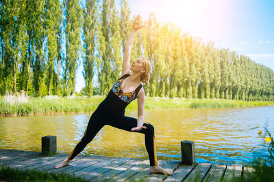 Side view of woman standing by lake