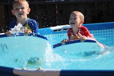 Happy brothers playing in swimming pool