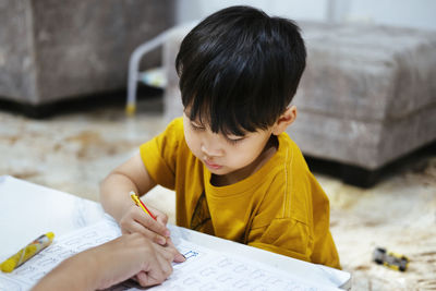 Full length of a boy sitting on book