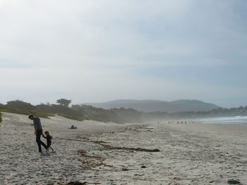 Man standing on beach against sky