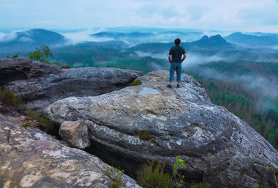 Man enjoy view at foggy morning in saxon switzerland. saxony region, germany