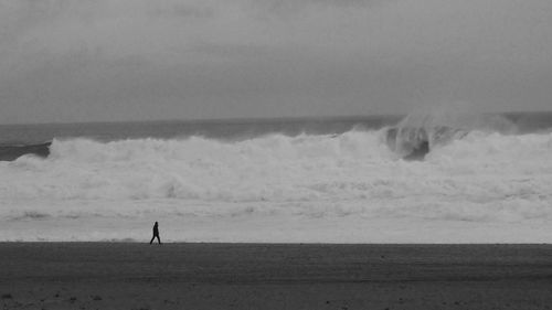 Man standing on beach against sky