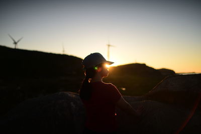 Rear view of woman standing against sky