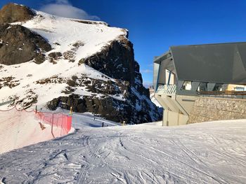 Snow covered houses by buildings against sky