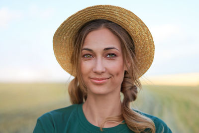 Portrait of smiling young woman against sky