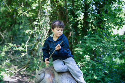 Boy sitting in forest