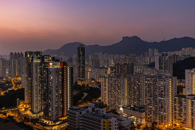 Illuminated cityscape against sky during sunset