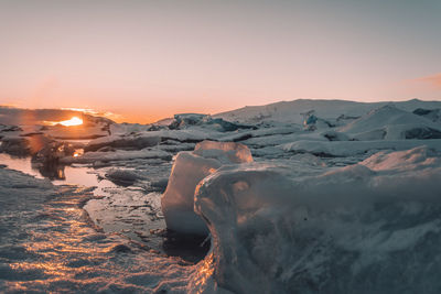 Scenic view of iceberg  in glacier against sky during sunset