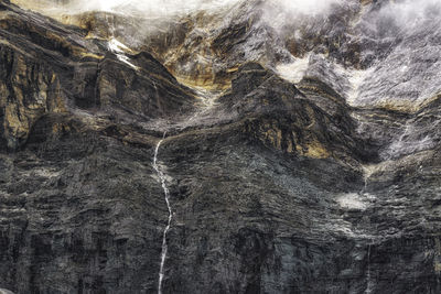 Rock formations and waterfall stream on land