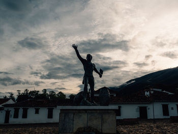 Low angle view of silhouette statue against building