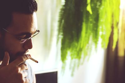 Side view of man wearing eyeglasses at home