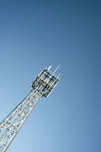 Low angle view of crane against clear blue sky