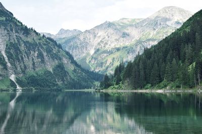 Scenic view of lake by mountains against sky