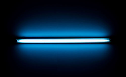 Close-up of illuminated light over blue background