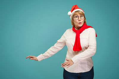 Portrait of young man standing against blue background