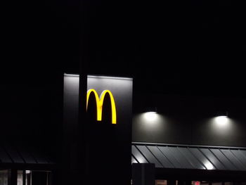 Low angle view of illuminated sign at night