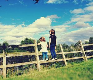 Children playing on field against sky