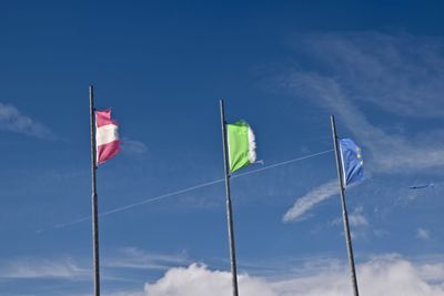 Low angle view of flags against blue sky