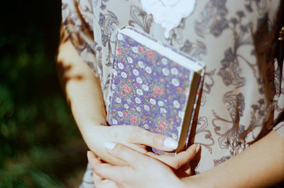 Midsection of woman holding floral pattern book