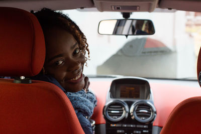 Portrait of young woman sitting in car