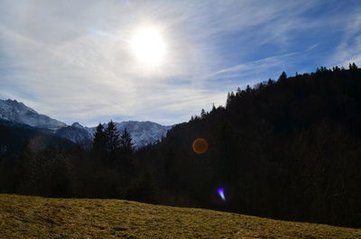 Scenic view of landscape against bright sun