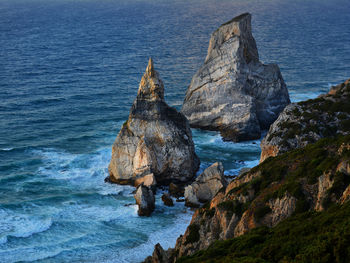 Rock formation in sea against sky