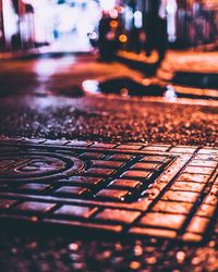 Close-up of wet street in city at night