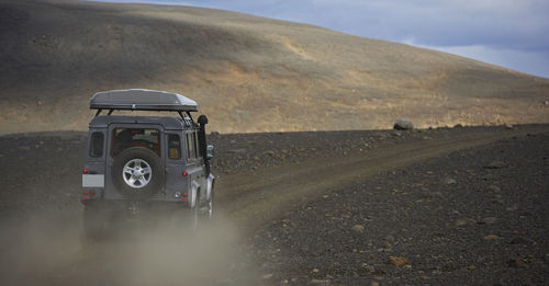 Suv driving on dusty road in central iceland