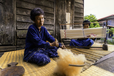 Senior women looming while sitting outdoors