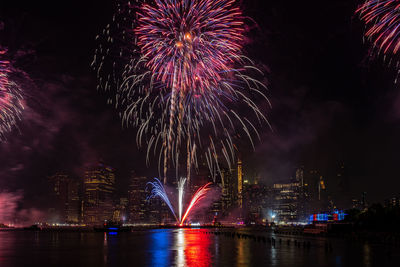 Firework display over river at night