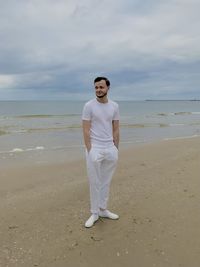 Full length of man standing on beach against sky