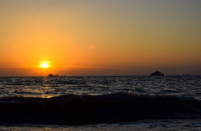 Scenic view of sea against orange sky