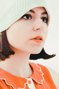 Close-up of thoughtful woman looking away against white background