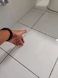 High angle view of hands on tiled floor