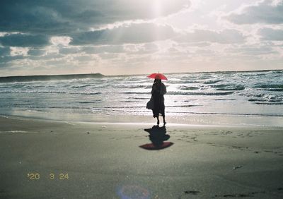 Full length of man standing on beach against sky